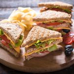 Group of club sandwiches with potato chips on wooden bacground,selective focus